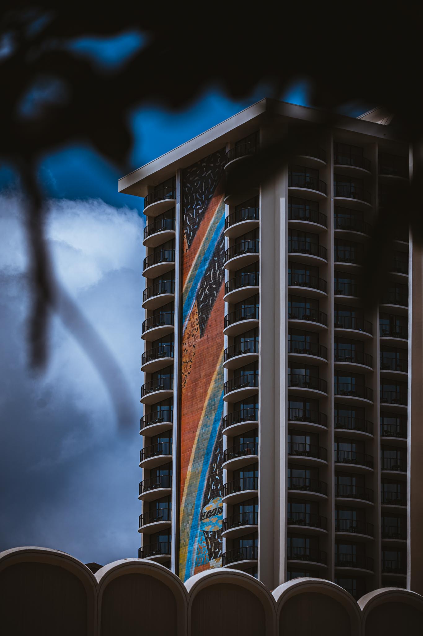 Diagonal mural on a tower against storm sky