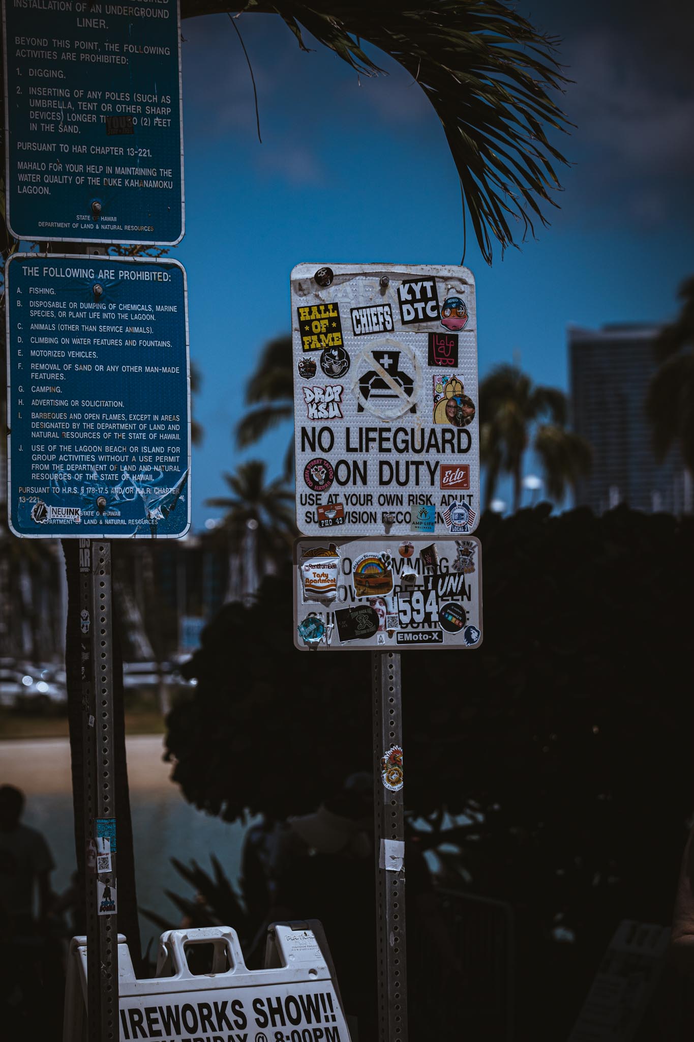 Stickered street sign at dusk