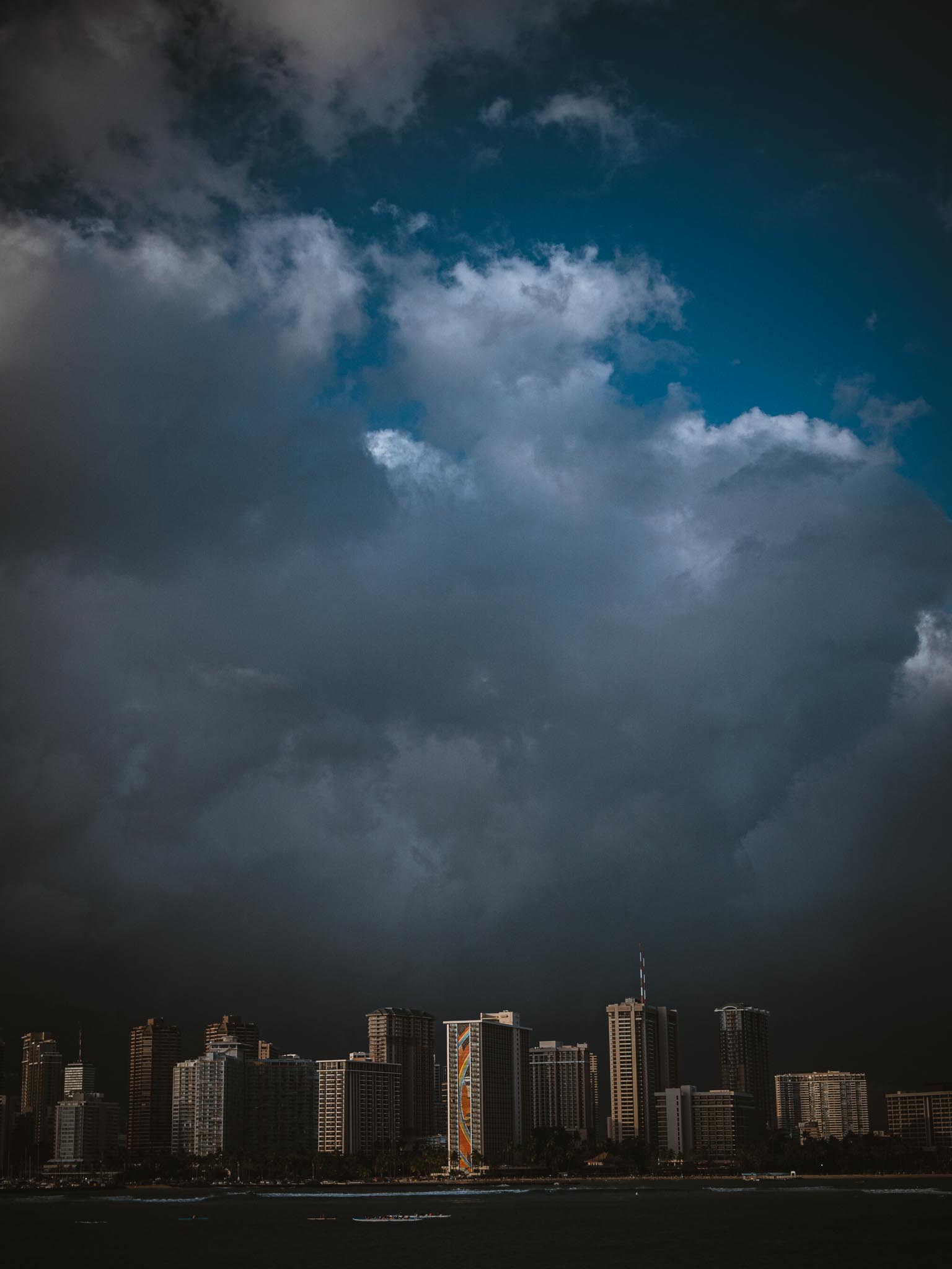 Storm cloud over a single lit tower