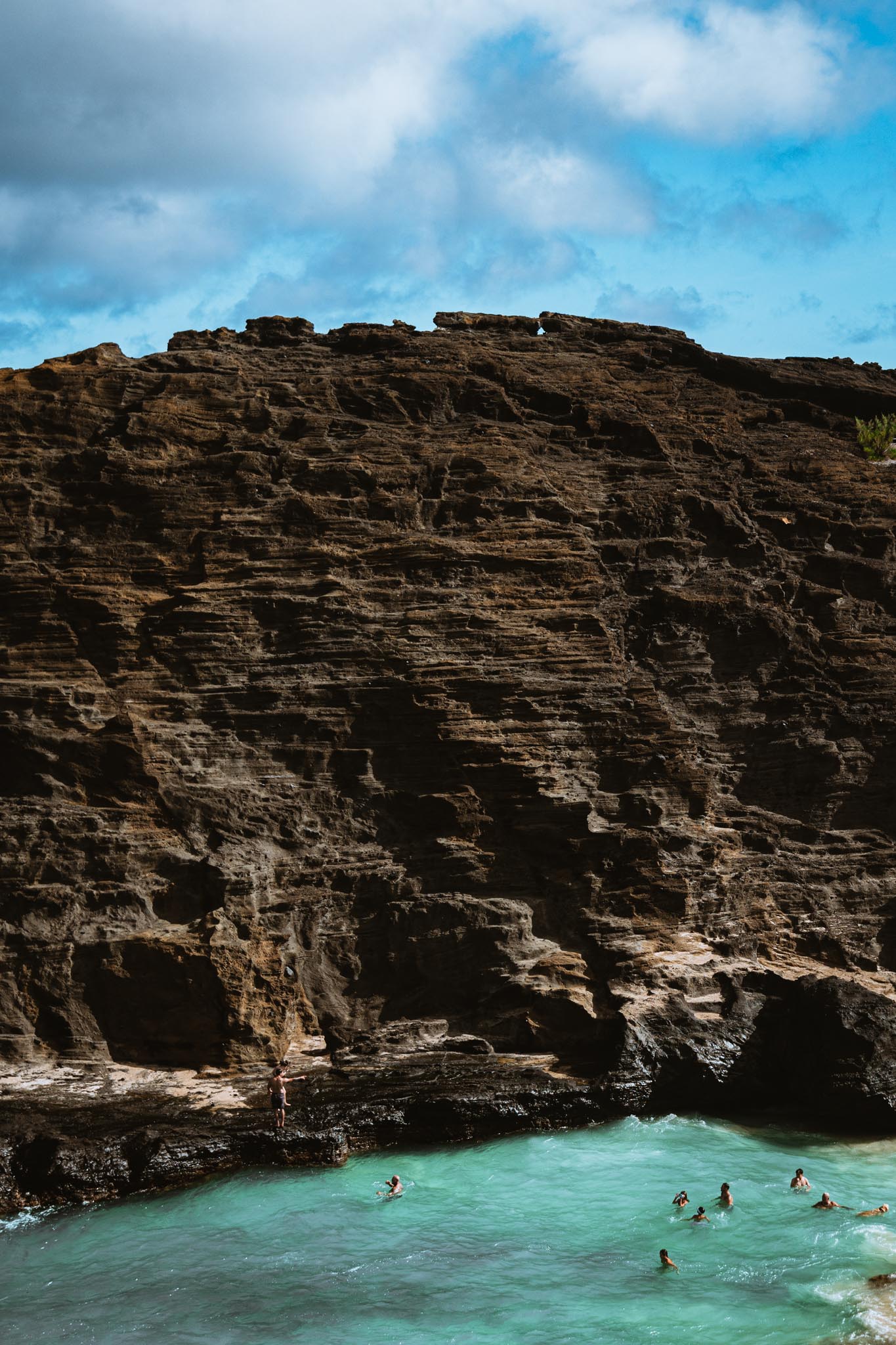 Layered cliff face above a turquoise cove
