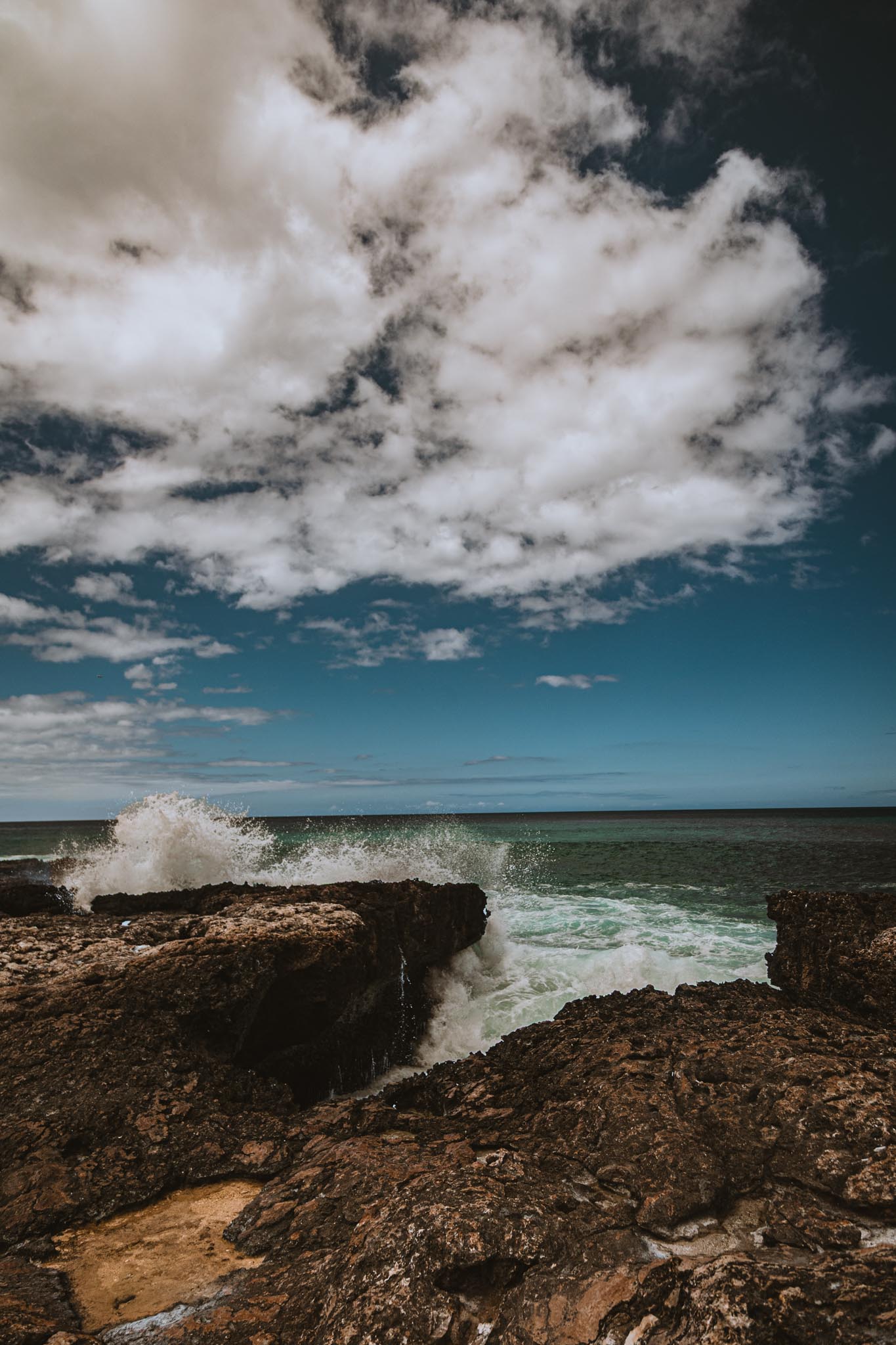 Surf breaking over dark rock